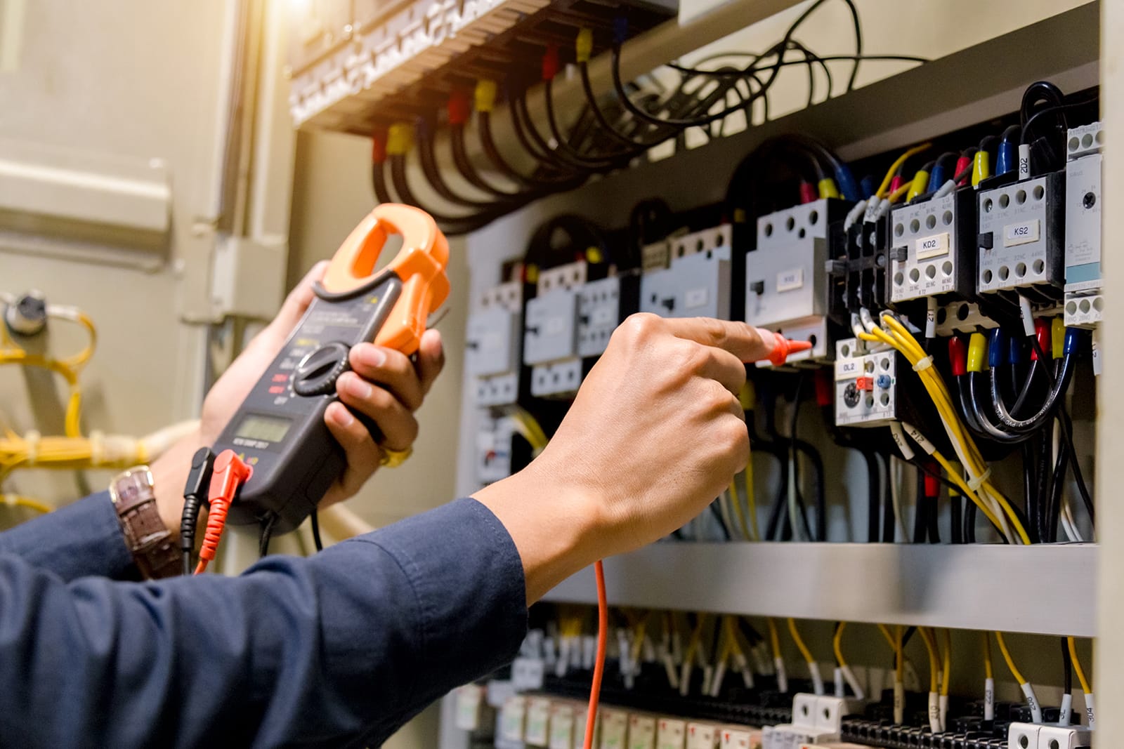 Electrician engineer work tester measuring voltage and current of power electric line.